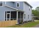 Side view of a light-blue home showcasing the screened in porch and the yard with landscaping at 1725 W Avalon Cir, Charleston, SC 29407