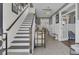 Elegant foyer with a staircase, stylish decor, brick floors, and an open view to the dining area at 1821 Mead Ln, Johns Island, SC 29455