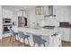 Modern white kitchen featuring a large island with seating, stainless steel appliances, and stylish pendant lighting at 1821 Mead Ln, Johns Island, SC 29455