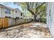 A spacious backyard features a wood fence, mature tree, patio, and grassy area at 2076 Wild Flower Ln, Charleston, SC 29414