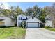 Charming two-story home with green lawn, mature trees, and an attached garage at 2076 Wild Flower Ln, Charleston, SC 29414
