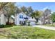 Charming two-story home with green lawn, mature trees, and an attached garage at 2076 Wild Flower Ln, Charleston, SC 29414