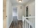 Upstairs hallway with gray wood floors, white trim, and access to bedrooms and bathrooms at 2076 Wild Flower Ln, Charleston, SC 29414