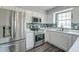 Modern kitchen with stainless steel appliances, white cabinets, backsplash, and grey floors at 2076 Wild Flower Ln, Charleston, SC 29414