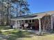 Inviting covered back patio featuring a grill, comfortable seating, and a well-manicured lawn at 260 Carolina Cir, Walterboro, SC 29488