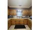 Classic kitchen featuring dark wooden cabinetry, stainless sink, ample counter space, and under-cabinet lighting at 260 Carolina Cir, Walterboro, SC 29488