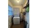 A compact laundry room featuring a stacked washer and dryer with water heater at 260 Carolina Cir, Walterboro, SC 29488