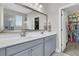 Bright bathroom with dual sinks, gray cabinets, and a view into the walk-in closet at 271 Palmetto Walk Dr, Summerville, SC 29486