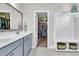 Bright bathroom with dual sinks, gray cabinets, and a peek into the walk-in closet at 271 Palmetto Walk Dr, Summerville, SC 29486