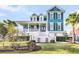 Charming two-story teal home featuring a welcoming front porch, well-manicured lawn, and lush landscaping at 2777 Oak Manor Dr, Mount Pleasant, SC 29466