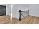 Hallway with wooden floors, modern railing, and a black door leading to another room at 2777 Oak Manor Dr, Mount Pleasant, SC 29466