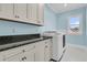 Cozy laundry room with a front load washer and dryer set and beautiful cabinetry at 2777 Oak Manor Dr, Mount Pleasant, SC 29466