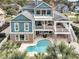 Expansive rear exterior showcasing a pool, fire pit, multiple decks, and lush landscaping with palm trees at 2777 Oak Manor Dr, Mount Pleasant, SC 29466