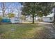 Spacious backyard with a mature tree, green grass, outbuildings and fence at 305 Meadowlark Ln, Moncks Corner, SC 29461