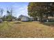Large backyard featuring lush lawn, mature shade tree, a storage shed, and patio area at 305 Meadowlark Ln, Moncks Corner, SC 29461