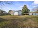 Sprawling backyard showing the house exterior, patio, sheds and mature tree at 305 Meadowlark Ln, Moncks Corner, SC 29461
