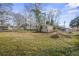 Expansive backyard featuring lush lawn, storage sheds, and surrounding trees at 305 Meadowlark Ln, Moncks Corner, SC 29461