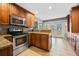 Bright kitchen with stainless steel oven and microwave, warm wood cabinets, and access to the backyard at 305 Meadowlark Ln, Moncks Corner, SC 29461