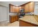 Kitchen with stainless steel oven and microwave, lovely granite countertops, and warm wood cabinets at 305 Meadowlark Ln, Moncks Corner, SC 29461