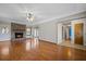 Open living room with a brick fireplace, wood floors, and a seamless flow to other living spaces at 305 Meadowlark Ln, Moncks Corner, SC 29461