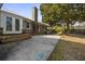 Outdoor patio with brick chimney, wooden steps, and an expansive backyard with a mature tree at 305 Meadowlark Ln, Moncks Corner, SC 29461