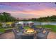 Outdoor fire pit with seating area, lake views, and string lights at dusk, perfect for relaxing and entertaining at 406 Summers Dr, Summerville, SC 29485