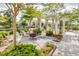 Firepit area with white Adirondack chairs under a pergola in a landscaped area of the neighborhood at 406 Summers Dr, Summerville, SC 29485