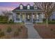 Inviting two-story home with a covered porch, complete with columns, a ceiling fan, and an American flag at 406 Summers Dr, Summerville, SC 29485