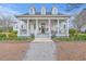 Charming two-story home with a welcoming front porch, columns, dormer windows, and manicured landscaping at 406 Summers Dr, Summerville, SC 29485