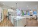 Bright kitchen features a central island with white cabinets and stainless steel appliances and flows into the living area at 406 Summers Dr, Summerville, SC 29485