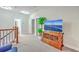 Loft area with wood railing, large TV, plant, and neutral carpet at 406 Summers Dr, Summerville, SC 29485