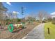 Community playground with various structures and play equipment for children of all ages, surrounded by a green space at 406 Summers Dr, Summerville, SC 29485