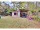 Backyard shed featuring an open design with wood details, a blue door and surrounding foliage adding charm at 407 Boone Hill Rd, Summerville, SC 29483