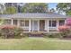Charming brick home featuring a quaint front porch and colorful blooming shrubs enhancing its curb appeal at 407 Boone Hill Rd, Summerville, SC 29483