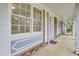 Classic porch with white trim and brick accents, offering a charming and welcoming entrance to the home at 407 Boone Hill Rd, Summerville, SC 29483