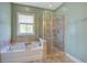 A bright bathroom with a separate soaking tub and glass enclosed shower at 4303 Misty Hollow Ln, Ravenel, SC 29470