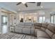 Open-concept living area with sectional seating and view into bright, modern kitchen at 4303 Misty Hollow Ln, Ravenel, SC 29470