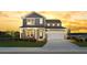 Inviting two-story home with a two-car garage, covered porch, and beautifully landscaped front yard at sunset at 5223 Cottage Landing Dr, Summerville, SC 29485