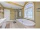 Bright bathroom with tiled floor, a glass shower, and a separate soaking tub at 5411 Nesting Pl, North Charleston, SC 29420