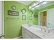 Stylish bathroom featuring double sinks and an artfully decorated green wall at 5411 Nesting Pl, North Charleston, SC 29420