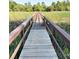 Inviting wooden boardwalk traversing through a grassy marshland at 5411 Nesting Pl, North Charleston, SC 29420