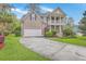 Charming two-story home with a spacious front yard, a two-car garage and a welcoming double-decker porch at 5411 Nesting Pl, North Charleston, SC 29420
