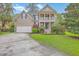 Charming two-story home featuring a spacious front yard, two-car garage, and a welcoming double-decker porch at 5411 Nesting Pl, North Charleston, SC 29420