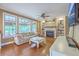 Cozy living room with a fireplace, built-in shelving, hardwood floors, and lots of natural light at 5411 Nesting Pl, North Charleston, SC 29420
