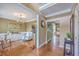 Hallway with hardwood flooring and neutral wall color, next to the living room with chandelier and wall trim at 5411 Nesting Pl, North Charleston, SC 29420