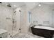Bathroom featuring a glass enclosed shower, soaking tub, marble-look walls, and sleek design at 6 Beverly Rd, Charleston, SC 29407