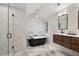 Spacious bathroom featuring marble-look walls, a free-standing soaking tub, and wooden vanity at 6 Beverly Rd, Charleston, SC 29407