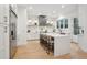 Bright, open kitchen with stainless steel appliances, white cabinets, island, and stylish marble backsplash at 6 Beverly Rd, Charleston, SC 29407