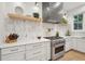 Well-appointed kitchen with open shelving, marble backsplash, stainless steel stove, and a modern range hood at 6 Beverly Rd, Charleston, SC 29407