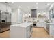 Modern kitchen features stainless appliances, white cabinets, light-grey island with bar seating, and light wood floors at 6 Beverly Rd, Charleston, SC 29407